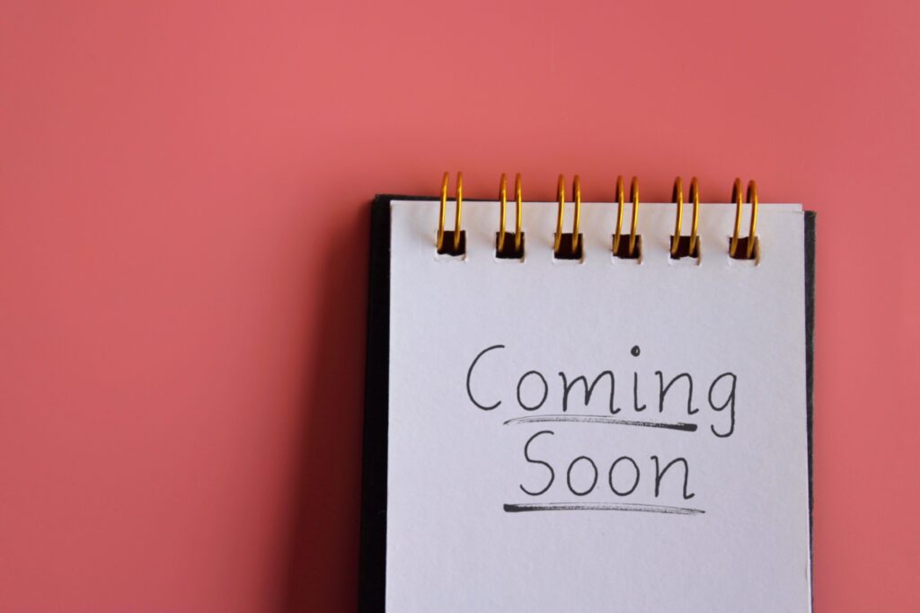 coming-soon-note-pink-background » milwaukeelingerie.com A spiral notepad with the handwritten words “Coming Soon” on a pink background—used to indicate upcoming Milwaukee lingerie lifestyle content.
