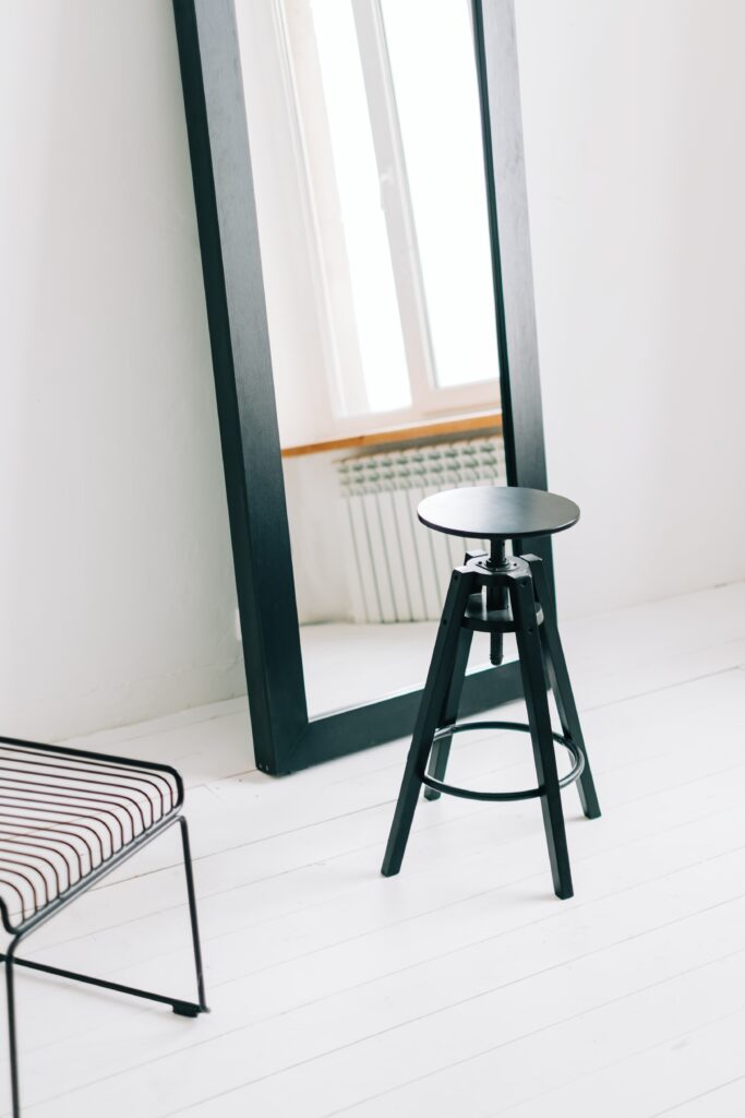 Big black mirror with black wooden chair in bright room near window » milwaukeelingerie.com minimalist-fitting-room-mirror-chair